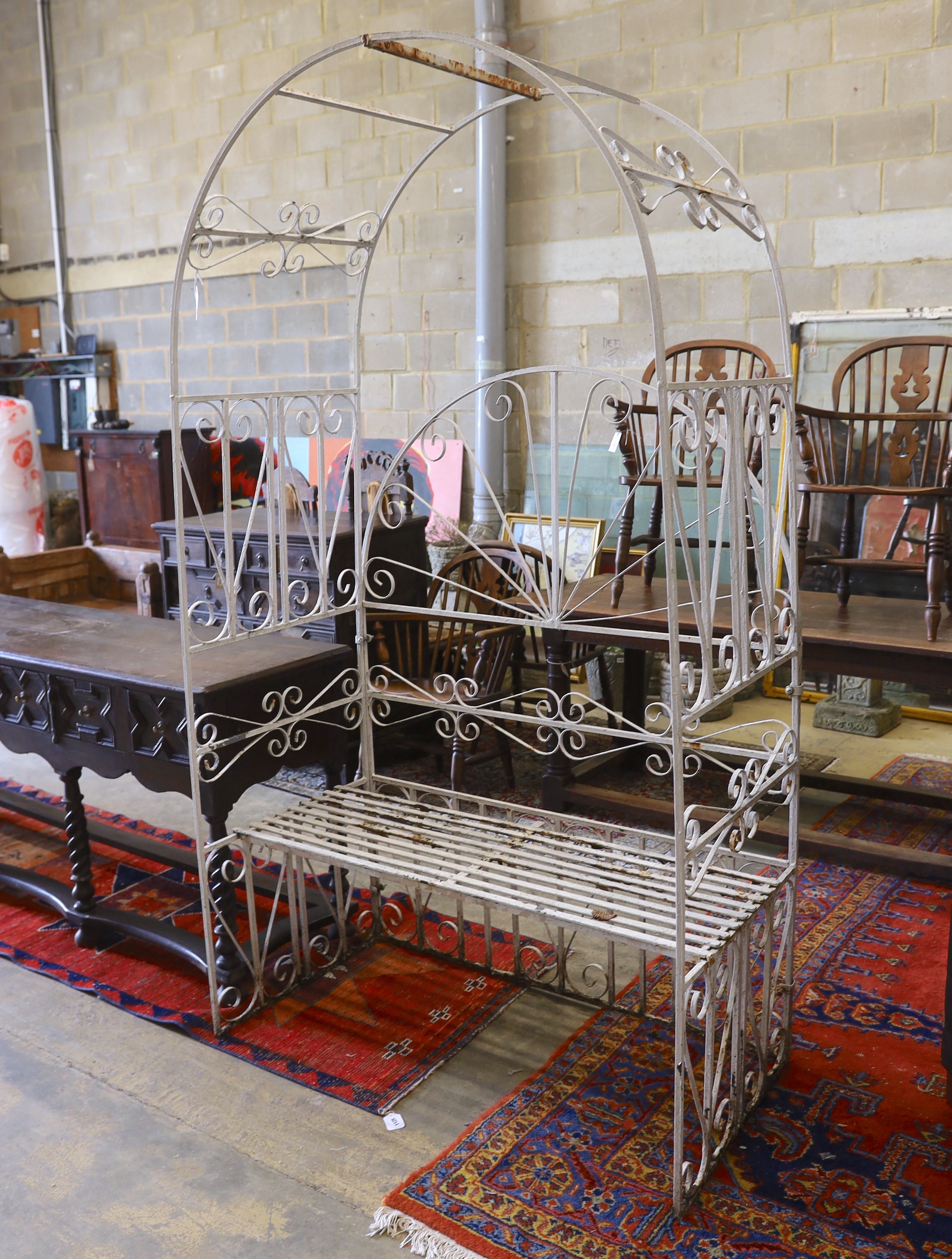 A painted wrought iron rose arbour garden seat, width 120cm, depth 62cm, height 218cm